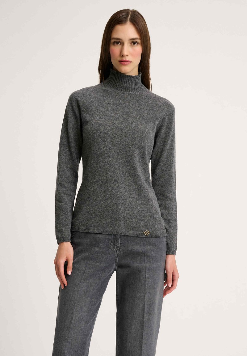 Grauer Rollkragenpullover aus weichem Material, mit langen Ärmeln und figurbetontem Design. Er hat ein dezentes Texturmuster und ein kleines Logodetail.