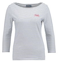 Randig långärmad skjorta i vitt och marinblått, med en vid halsringning och röd broderad "Polo"-logotyp på vänster bröst. Mjuk bomullsmaterial.