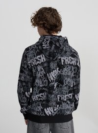 Czarna bluza z kapturem z nadrukiem w stylu graffiti w kolorach szarym i białym, z kapturem na sznurki i ściągaczami na rękawach, widziana od tyłu.