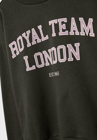 Felpa verde scuro con "ROYAL TEAM LONDON" in grandi lettere viola e "EST. 1965" in lettere bianche più piccole sottostante.