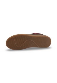 Semelle de chaussure en caoutchouc, avec un motif de semelle ondulée de couleur tan, comportant des rainures texturées pour la prise et la stabilité.
