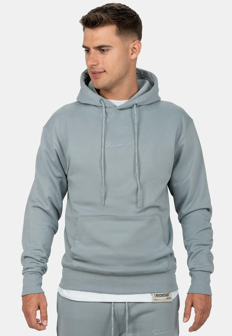 Felpa con cappuccio grigia chiara, dotata di tasca frontale, cordini regolabili, polsini a costine e un ricamo del logo discreto sul petto e sull'orlo.