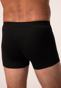 Boxer neri realizzati in tessuto morbido, caratterizzati da un colore uniforme e un elastico stretto con la scritta "JP1880" impresso.