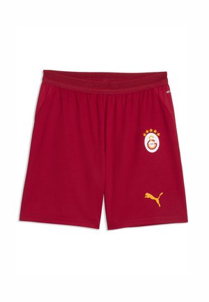 Røde sportsshorts med elastisk taljebånd, med en gul Puma-logo og et hvidt, rødt og gult Galatasaray fodboldklubemblem med fem stjerner.