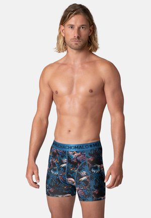 Heren boxershorts in een tropisch patroon met levendige kleuren tegen een blauwe achtergrond. Elastische tailleband met "MUCHACHO" branding.