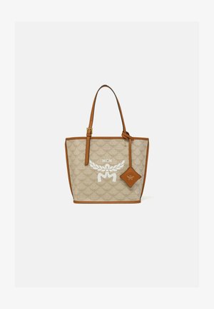 Borsa a tracolla in tela beige con un motivo intrecciato, bordi in pelle marrone e manici. Presenta un logo bianco e un'etichetta in pelle marrone attaccata.
