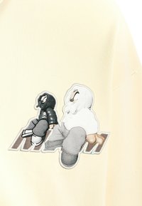 Dos personajes de dibujos animados, uno vestido de negro y otro de blanco, sentados de espaldas en un fondo de tela beige.