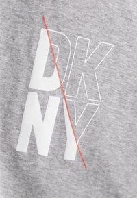 Grijze stof met een gestructureerde uitstraling, met de letters "DKNY" in het wit en een kruisende rode lijn voor extra nadruk.