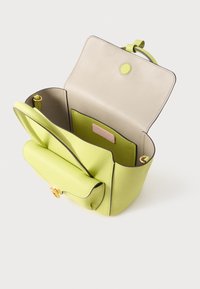 Ανοιχτοπράσινη δερμάτινη τσάντα χειρός με μπεζ εσωτερικό, ανοιχτό καπάκι, χρυσή αγκράφα, μπροστινή τσέπη και εσωτερική επίπεδη τσέπη με ροζ ετικέτα.