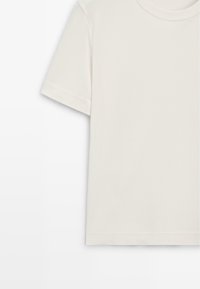 T-shirt z krótkim rękawem w kremowym kolorze, wykonany z bawełny, charakteryzujący się klasycznym półokrągłym dekoltem, gładką fakturą i czystym wykończeniem bez wzorów czy akcentów.