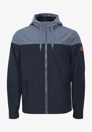 Chaqueta con cremallera en azul marino y azul claro, con capucha, paneles de color contrastante, cordones y detalle de bolsillo lateral.