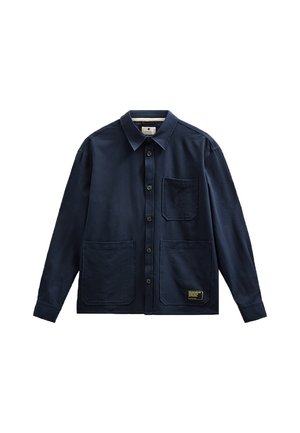 Camisa azul marino de manga larga con botones, tres bolsillos delanteros, cuello y una pequeña etiqueta negra y amarilla en el bolsillo inferior derecho.