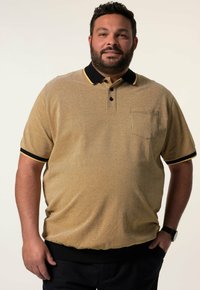 Polo tričko s krátkým rukávem ve světle žluté barvě s texturovaným povrchem. Černý límec a manžety s žlutým lemem. Disponuje kapsou na přední straně.