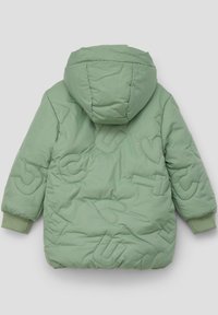 Veste matelassée verte avec capuche, présentant des lettres et formes en relief. Poignets côtelés et texture lisse.