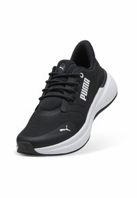 Zwarte sportieve schoen met een mesh bovenwerk, voorzien van een wit Puma-logo, vetersluiting, gevoerde kraag en een witte tussenzool.