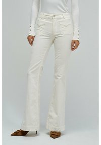 Jeans blancos acampanados con una cintura de altura media, con bolsillos frontales y cierre de botón. Tejido suave con una ligera textura.