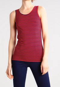 Punainen ja laivastonsininen raidallinen hihaton paita, jossa on pyöreä kaula-aukko ja kapea muotoilu. Kangas näyttää sileältä ja siinä on hengittävä rakenne.