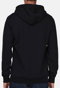 Black hoodie featuring a drawstring hood, ribbed cuffs, and waistband, made from a soft, textured fabric. Back view with no patterns or logos.