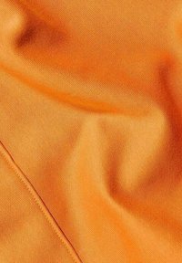 Tejido naranja con una superficie lisa y texturizada, que presenta arrugas sutiles y un borde limpio. El material parece liviano y transpirable.