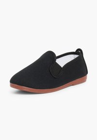Chaussure noire en toile à enfiler avec panneaux latéraux élastiques et semelle en caoutchouc marron, présentée légèrement de biais sur fond blanc.