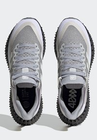 Sneakers grigie con tomaia in maglia testurizzata, lacci grigi e suola in gomma nera. Presentano dettagli lisci e un logo sulla linguetta.