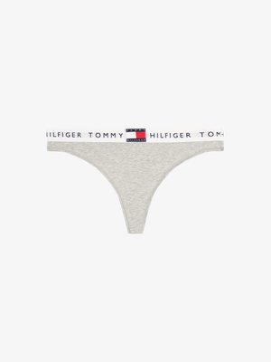 Perizoma grigio con cintura elastica bianca che presenta il testo "Tommy Hilfiger" e una piccola toppa con il logo rosso, bianco e blu al centro anteriore.