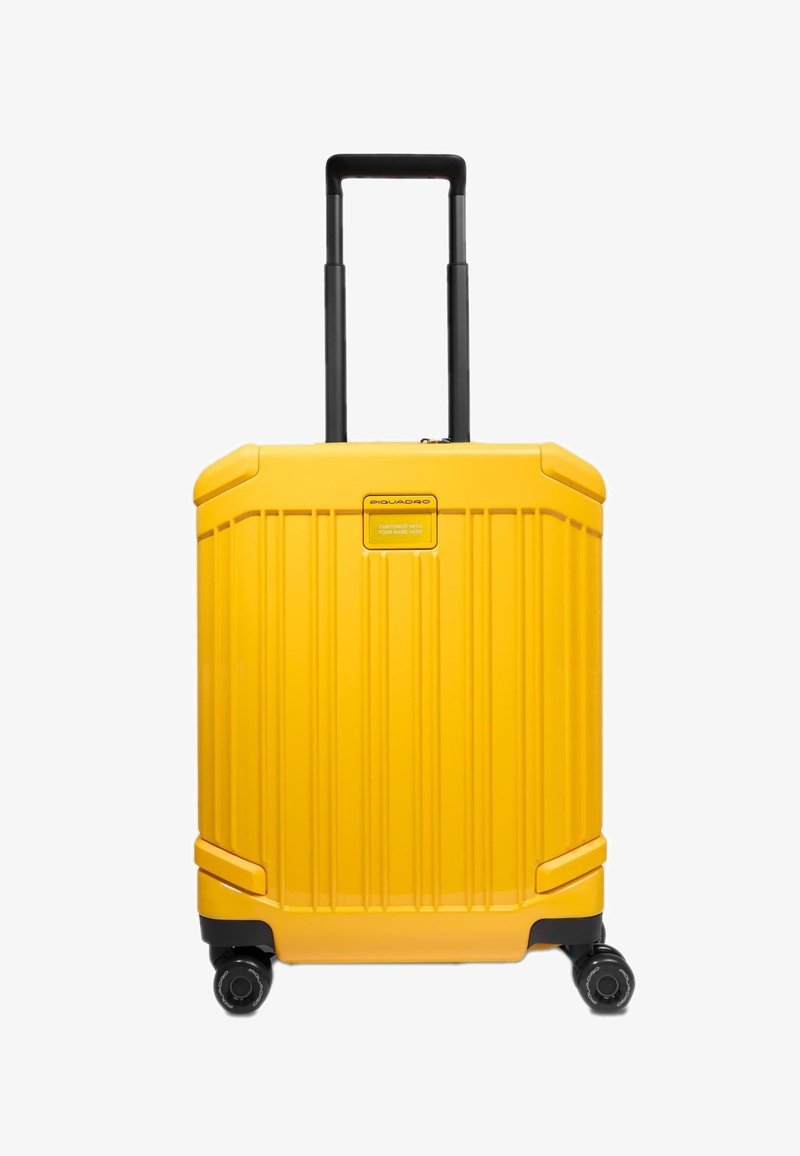 Valise rigide jaune avec quatre roues pivotantes noires et poignée télescopique noire déployée.