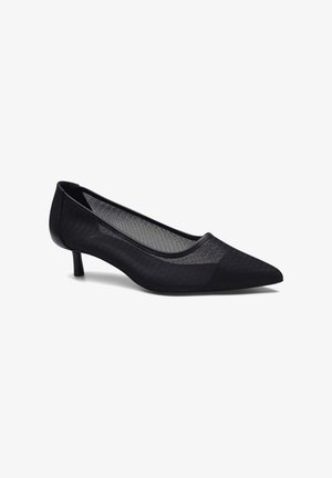 Escarpin noir à bout pointu avec un dessus en maille texturée, des contours en cuir fins et un petit talon. Présente une section transparente près de l'empeigne.