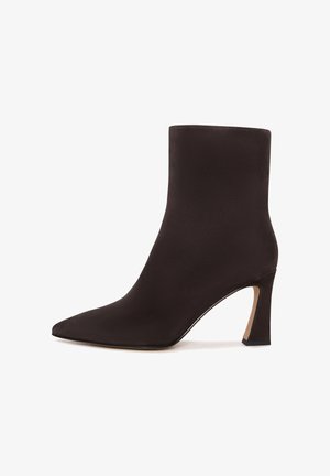 Stivaletto in suede nero con punta affusolata e tacco alto a campana, vista laterale su sfondo bianco.