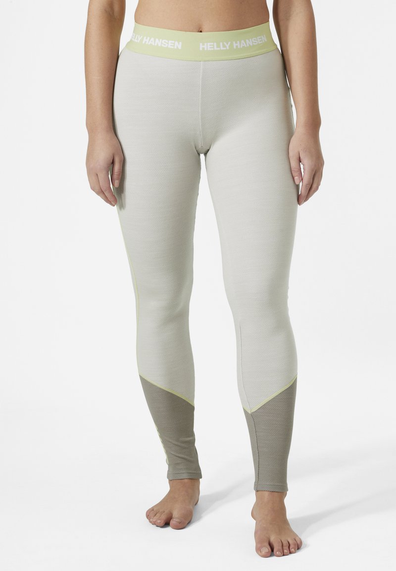 Leggings de color gris claro con un panel inferior beige en contraste y acentos amarillos. Presentan un material suave y elástico, así como una cintura elástica.