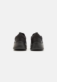 Zapatillas deportivas negras con parte superior de malla transpirable, talón texturizado, lengüetas de agarre y suela de goma ligera y con patrón.