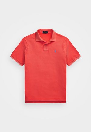 Rotes Poloshirt mit kurzen Ärmeln, Kragen, zwei Knöpfen und kleinem blauem Logo auf der linken Brust, flach auf weißem Hintergrund liegend.