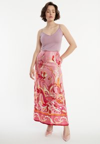 Roze bloemenprint maxi rok met een gladde textuur, met levendige vormen in rood en oranje, gecombineerd met een lavendelkleurig tanktop.