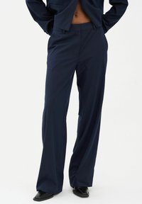 Navy blauwe pinstriped broeken met een rechte snit, gemaakt van een gladde stof, met een middelhoge taille en voorkeurszakken.