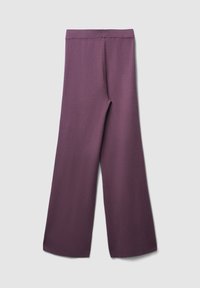weiten Hosen aus einem tiefpurpurnen Stoff mit strukturierter Oberfläche, hoch geschnitten und ohne sichtbare Verschlüsse oder Taschen.
