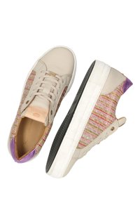 Beżowe sneakersy z plecionego, pastelowego materiału po bokach, fioletowe akcenty, fakturowana powierzchnia, sznurowany design oraz gumowa podeszwa z teksturowanym gripem.