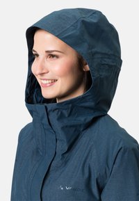 Giacca impermeabile blu navy con cappuccio, caratterizzata da una superficie liscia, zip frontale e un logo sul petto.