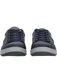 Marinblå sneakers med grå accenter, med snörning, gummisula och en enkel, strömlinjeformad design. Texturerat material runt ovandelen.