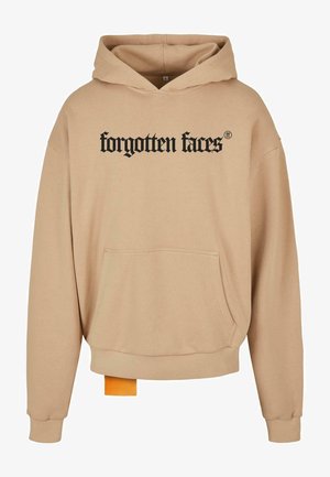 Beżowa bluza z kapturem z czarnym napisem "zapomniane twarze", kangurzą kieszenią, ściągaczami na rękawach oraz dołem z pomarańczową metką akcentującą. Miękka tekstura materiału.
