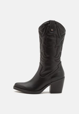 Bottes de cowboy en cuir noir avec une tige haute, des coutures décoratives, un bout pointu et un talon bloc à texture striée.