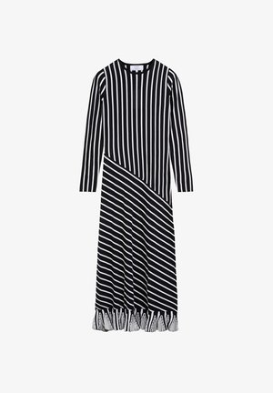 Robe maxi noire et blanche à manches longues avec des rayures verticales sur le haut, des rayures diagonales sur la jupe et un détail de franges à l'ourlet.
