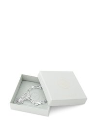 Silvrig armband med snöflingeberlock, visad i en ljusgrå presentask. Har en kedjedesign och en slät metallisk yta.