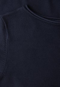 Tissu tricoté bleu marine avec une texture lisse, présentant un col rond et des accents côtelés subtils sur le col et les manches.