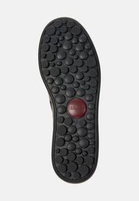 Semelle de chaussure en caoutchouc noir avec texture bulle ronde et un accent circulaire rouge central portant les inscriptions "camper" et "42 C".
