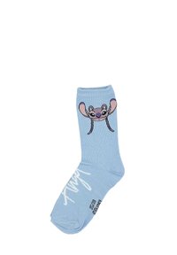 Calcetín de algodón azul claro con un diseño de personaje de dibujo animado en la parte frontal, que presenta grandes orejas y una cara sonriente. Texto blanco en el lateral.