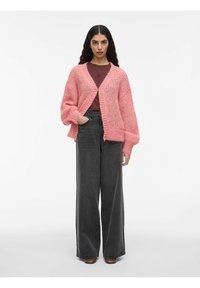 Cardigan rosa lavorato a maglia con vestibilità ampia, caratterizzato da una profonda scollatura a V e maniche larghe, abbinato a pantaloni grigi a gamba larga con vita alta.