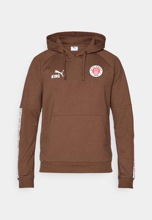 Bruine hoodie van zacht materiaal, met een voorzak, een capuchon met trekkoord en witte sportaccenten op de mouwen met een logo.
