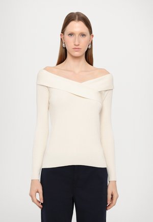 Off-white off-shoulder fitted top with long sleeves, ribbed texture, and folded neckline design. Paired with dark pants. Simple and elegant.