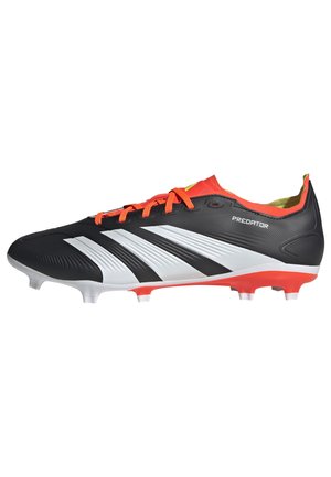 Chaussure de football noire avec des rayures blanches, des lacets rouges et des accents orange. Présente un upper texturé et une semelle extérieure pour terrain ferme avec des crampons blancs.