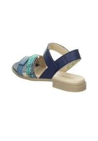 Blaue und grüne Sandale mit mehreren Riemen, strukturiertem Obermaterial, glatten Lederakzenten, offenem Rücken und einem niedrigen Blockabsatz.